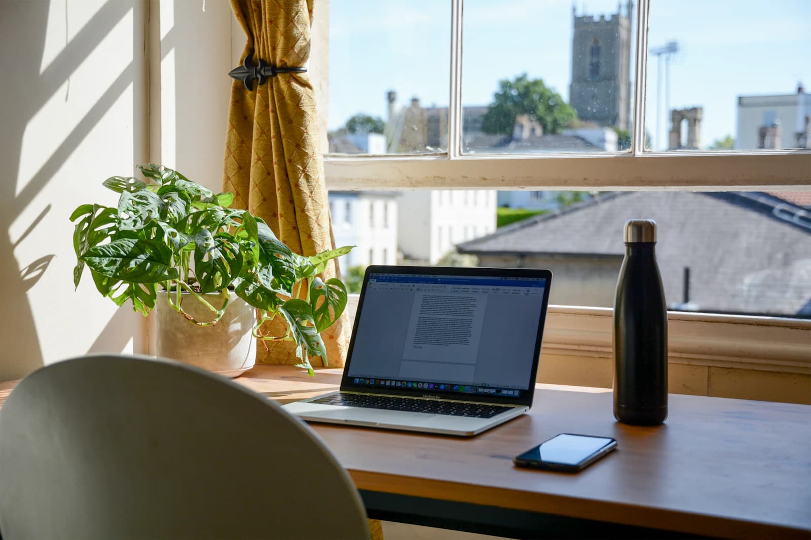 A laptop set up on a wooden desk in a home workspace